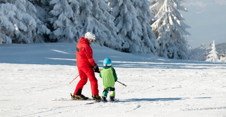 holding hands skiing together
